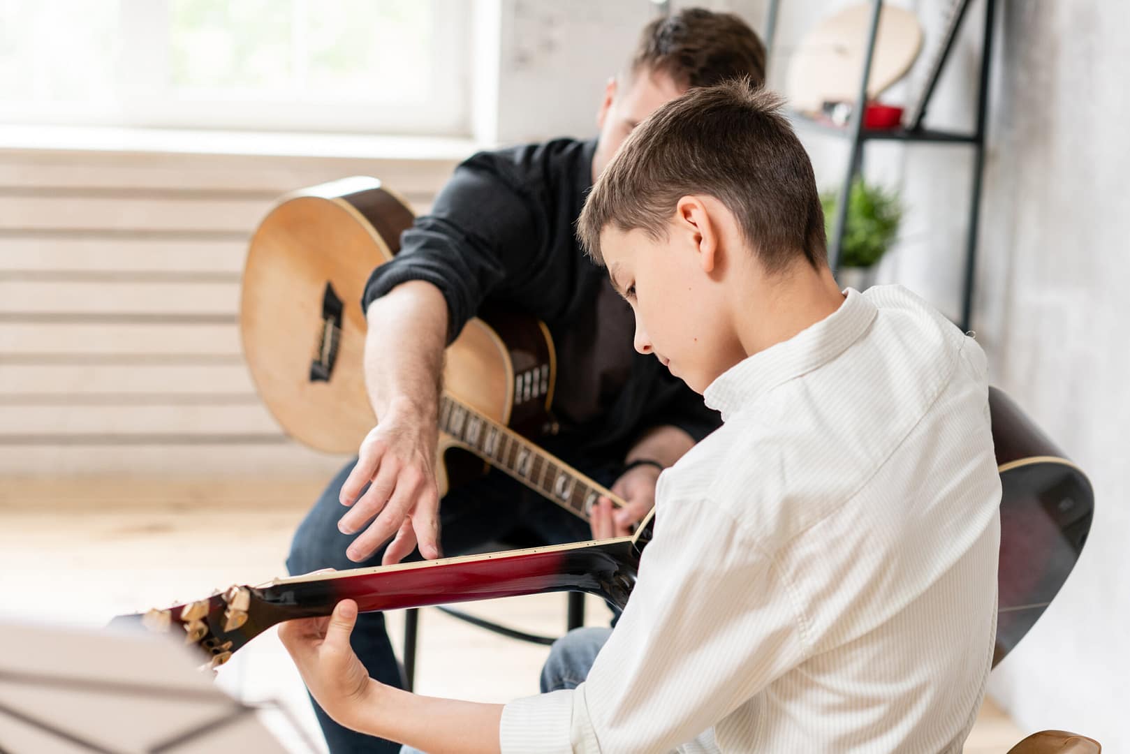 A Personal Tutor Explains To His Young Student How To Play Studied Chord Correctly. Musical Education At Home