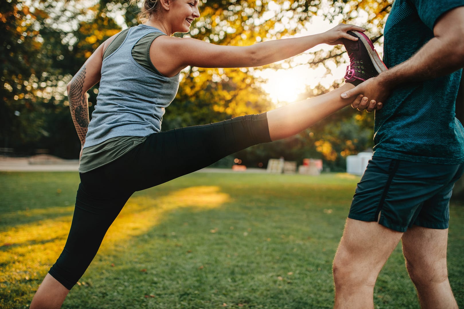 Woman Stretching With Help Of Personal Trainer