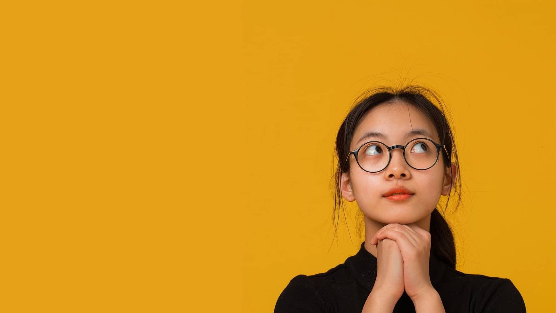 Young Asian girl looking into the air for answers